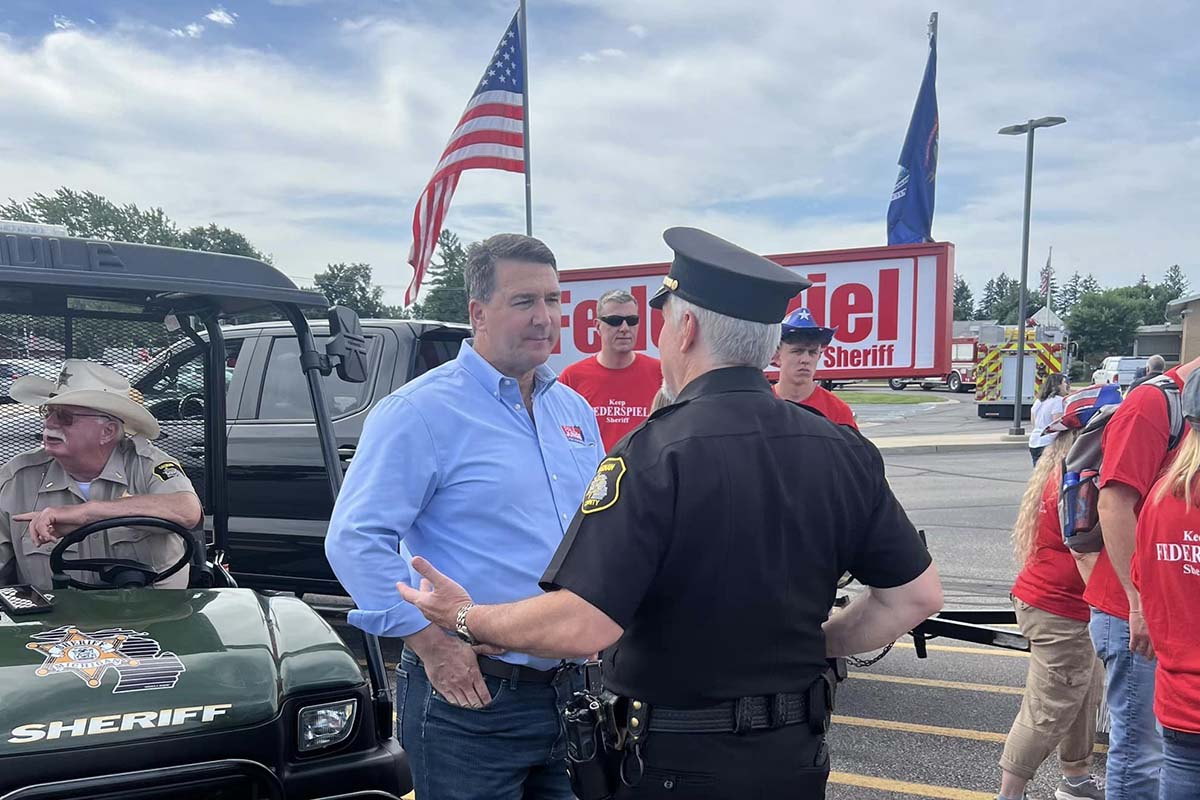 Paul Junge at a parade, talking to someone