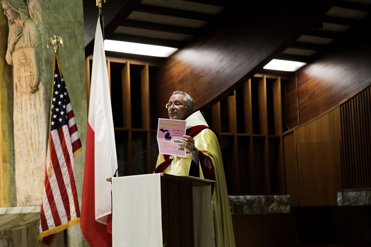 Rev. Alex Kratz holds up poster