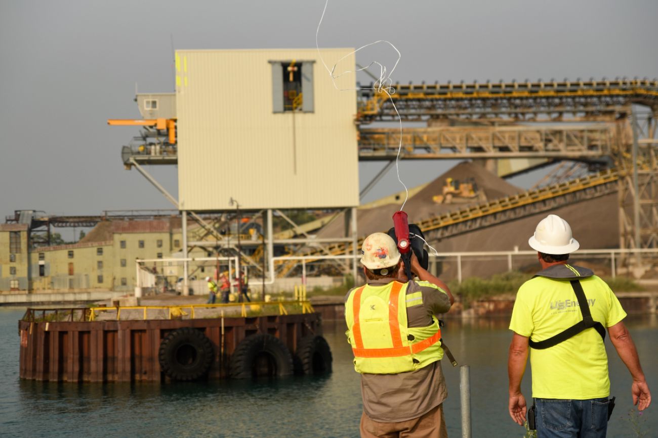 Men in construction hats stand on the bay