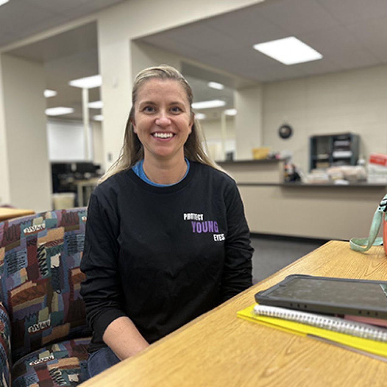 Heather Quellet sitting at a desk, posing for a picture