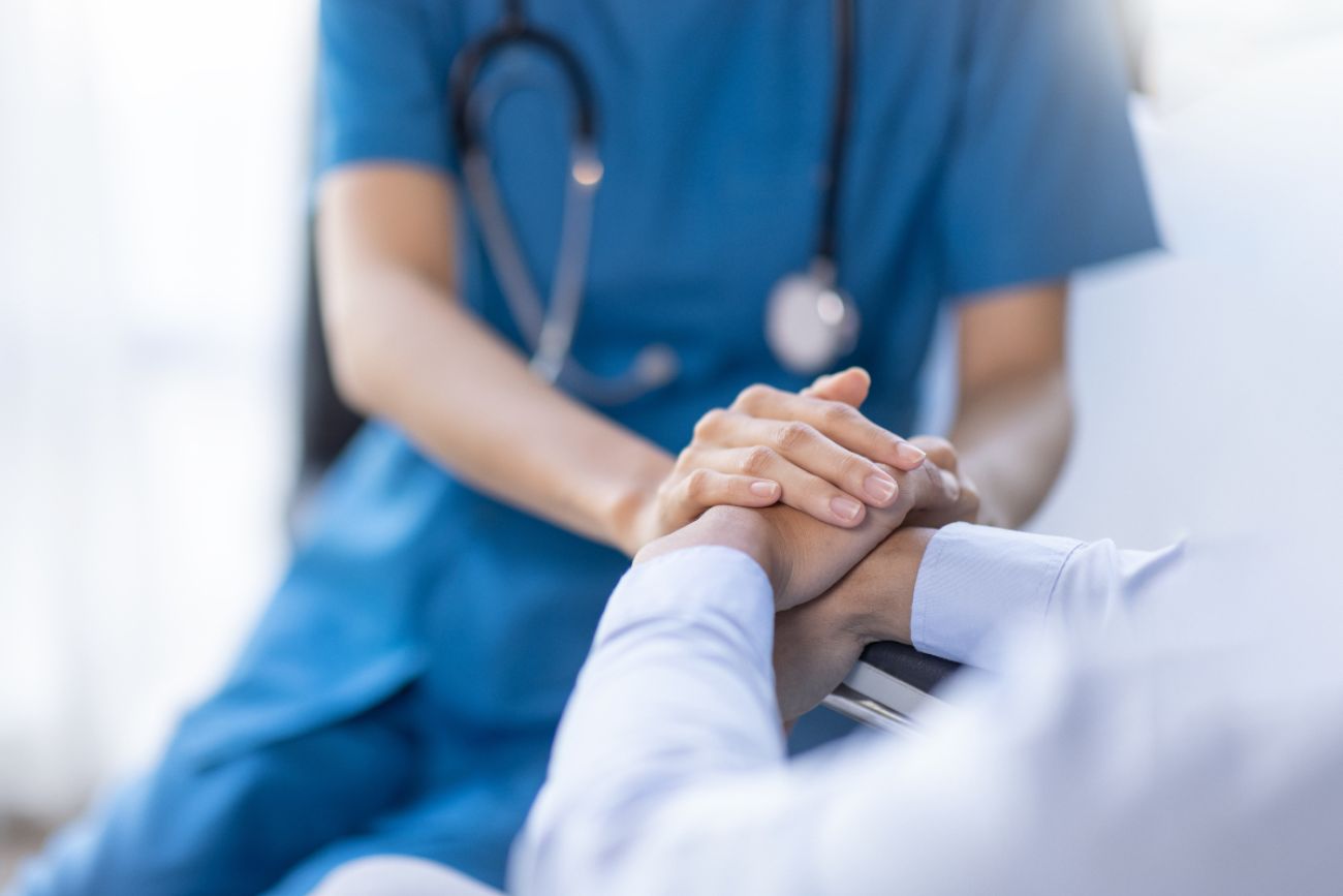 Doctor and patient hold hands