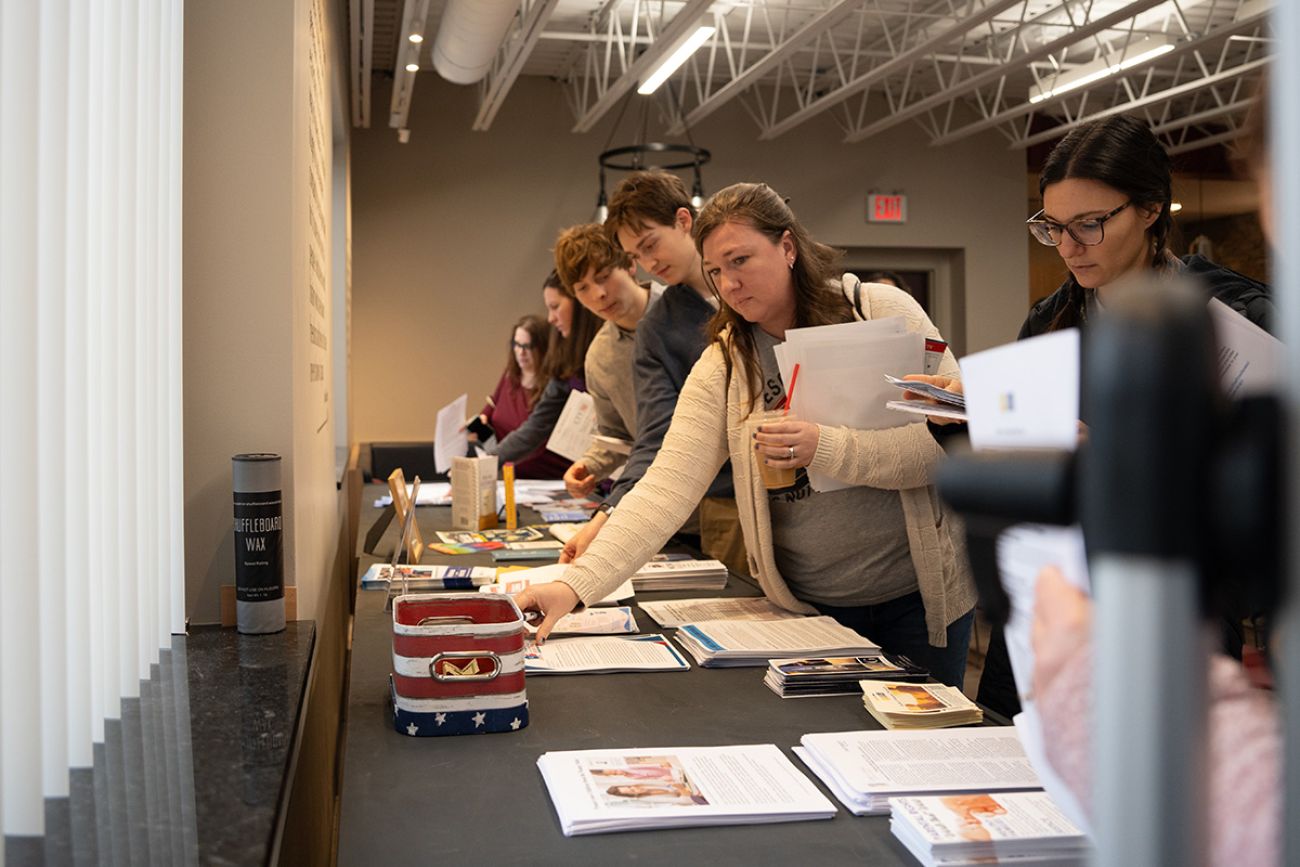 people picking up papers on a table