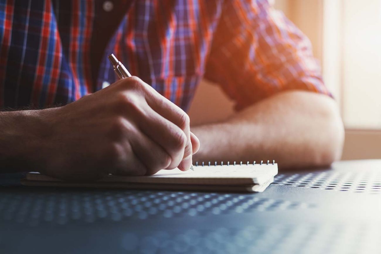 man writing in a notebook