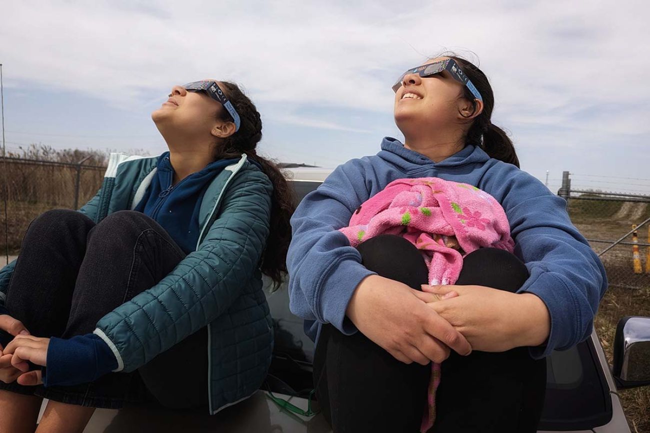 Mall sisters sitting on van looking at the sky