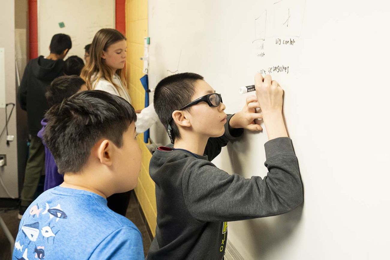 student writing on whiteboard