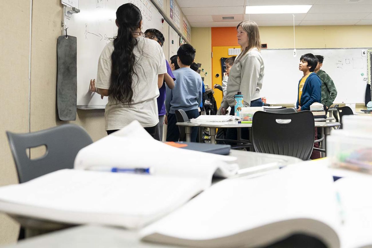 a bunch of students standing in front of whiteboard