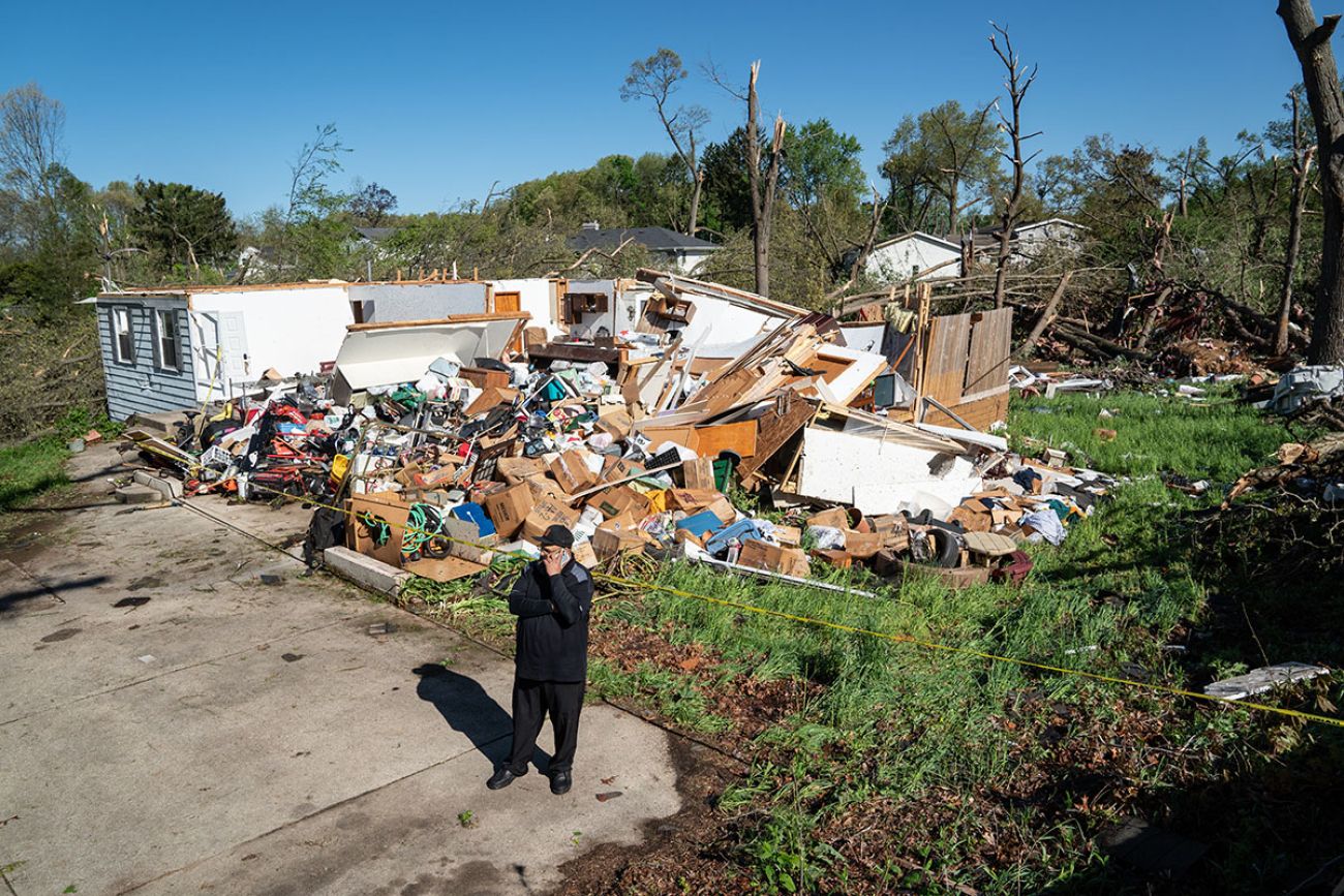 Man standing in front of a destroyed building in Portage, Michigan