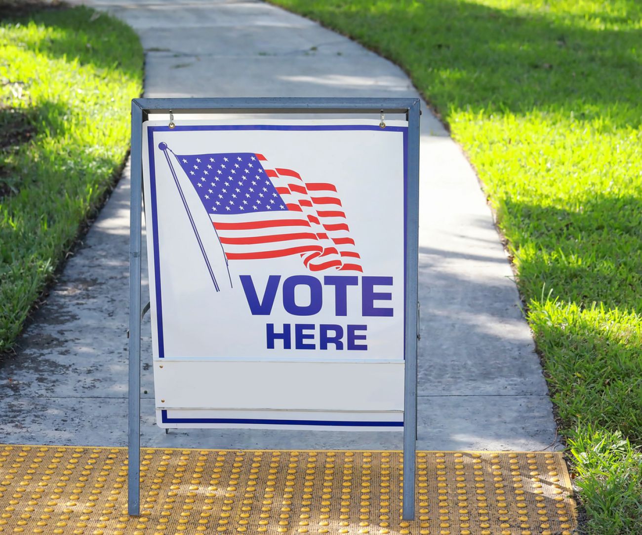 Vote here sign placed on the walkway to a neighborhood polling place