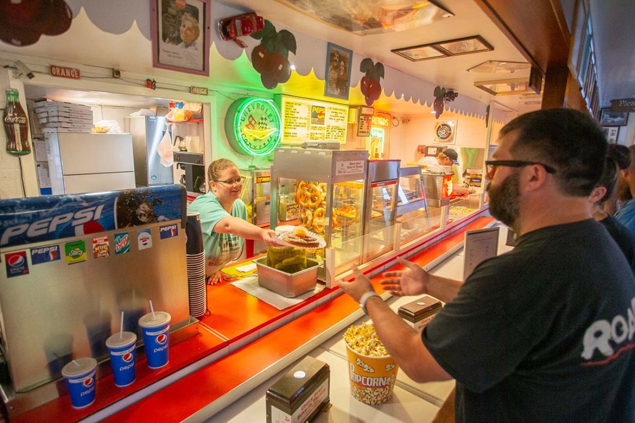 A man being handed nachos at the concession stands