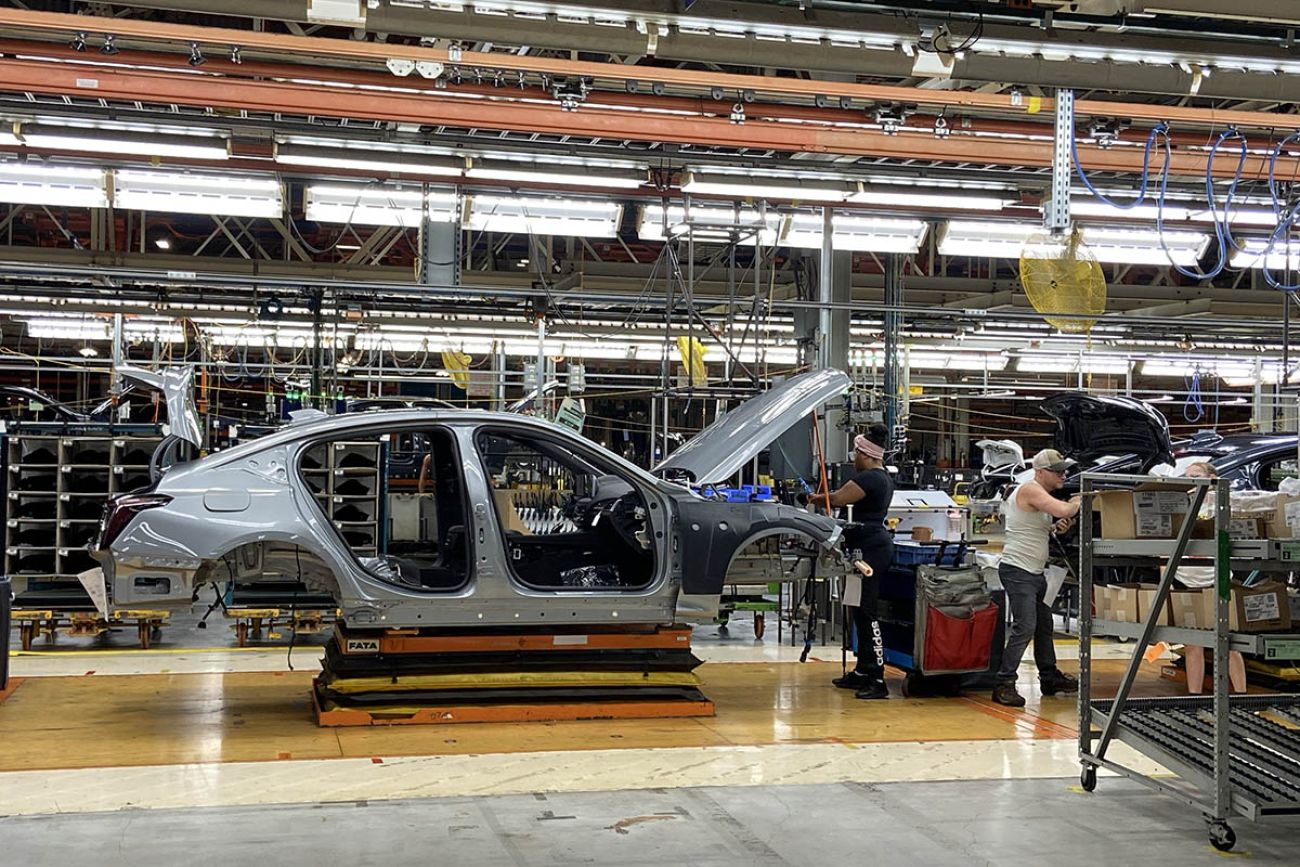 People working on a car in an assembly line