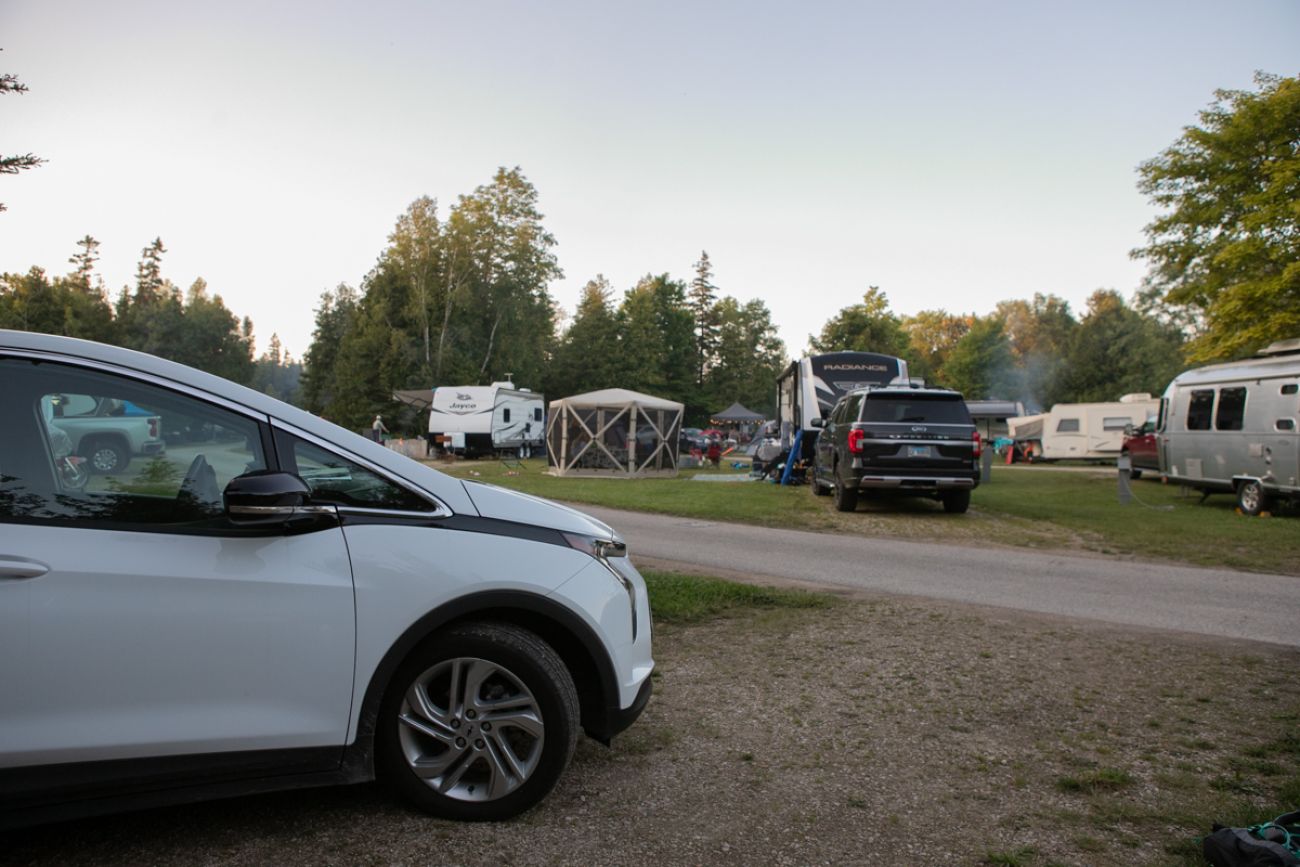 A white EV at a campsite