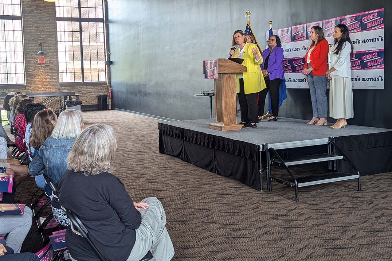 U.S. Rep. Elissa Slotkin standing on a stage, speaking to supporters who are seated