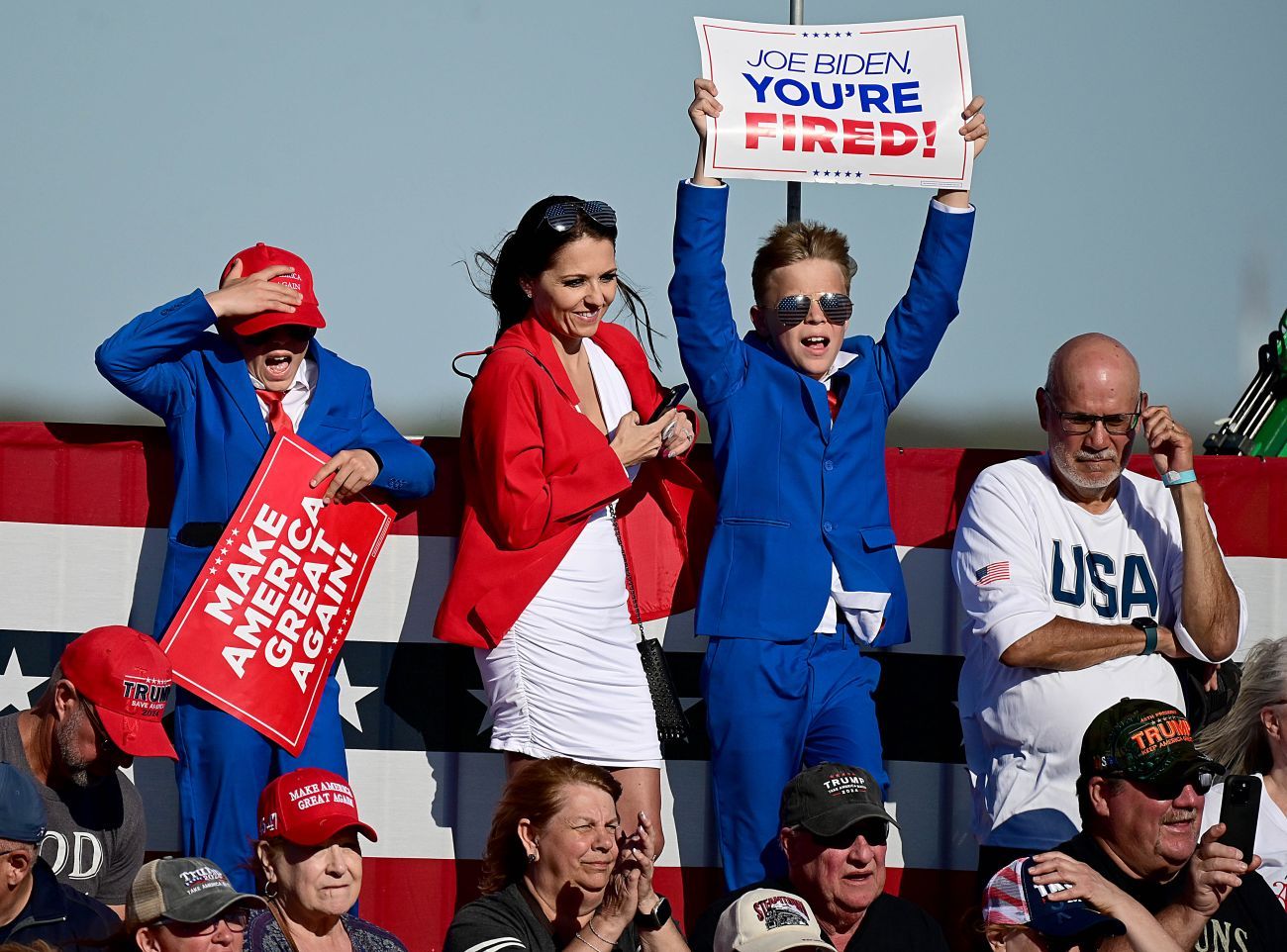 Supporters at a rally for Donald Trump. Kids holding Joe Biden you're fired sign