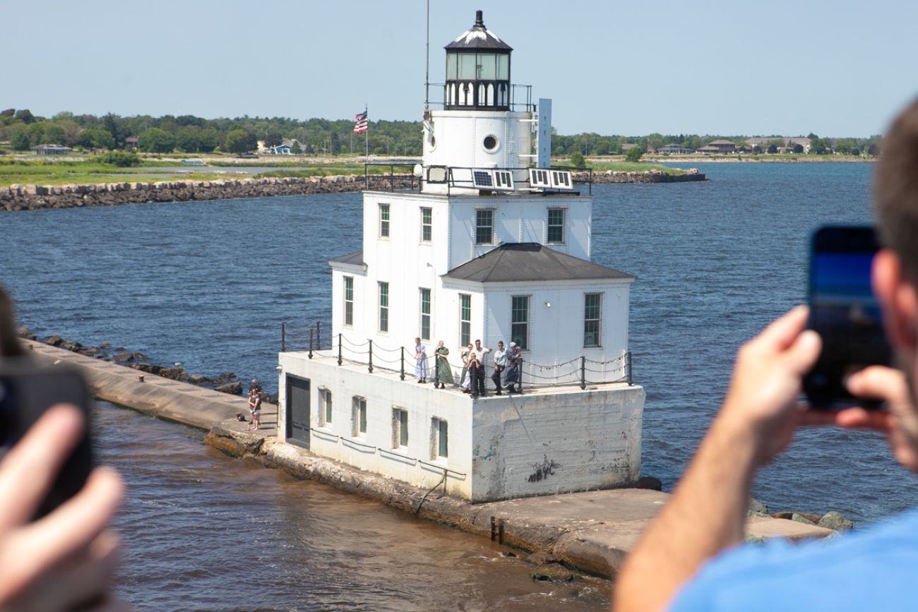 People taking pictures on the SS Badger of the Lake Michigan shore