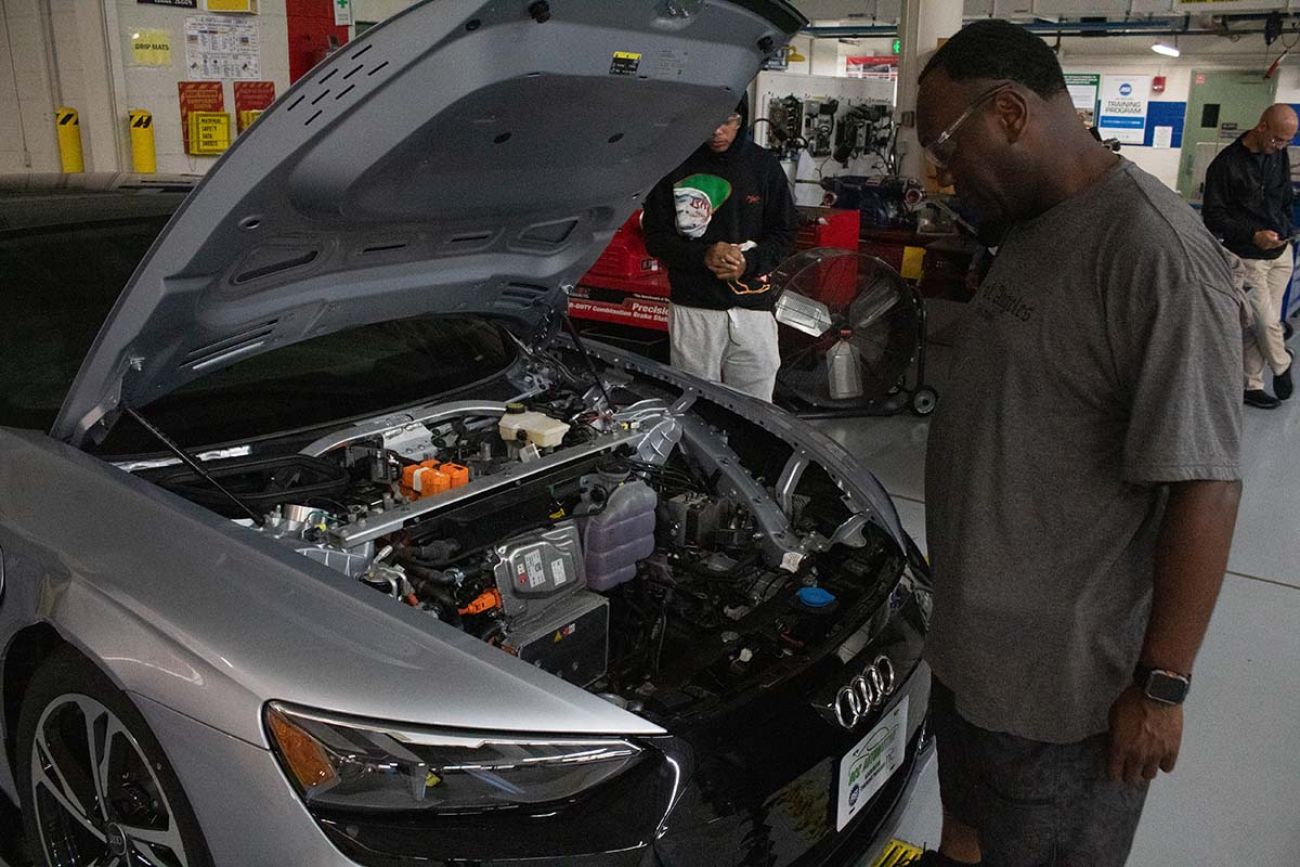 Ebitari Burutolu looks at the hood of a silver car