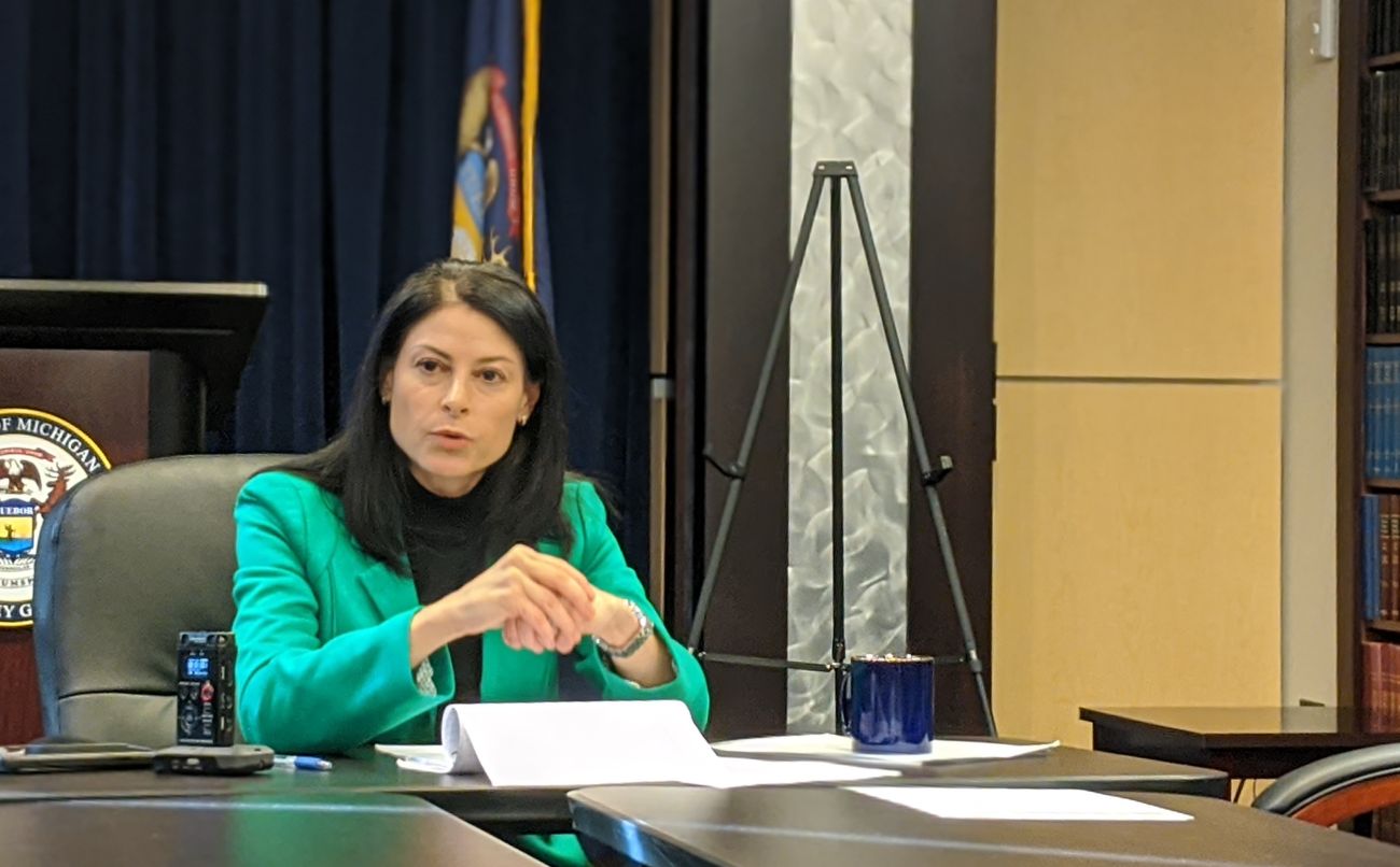 Michigan Attorney General Dana Nessel sits a table 