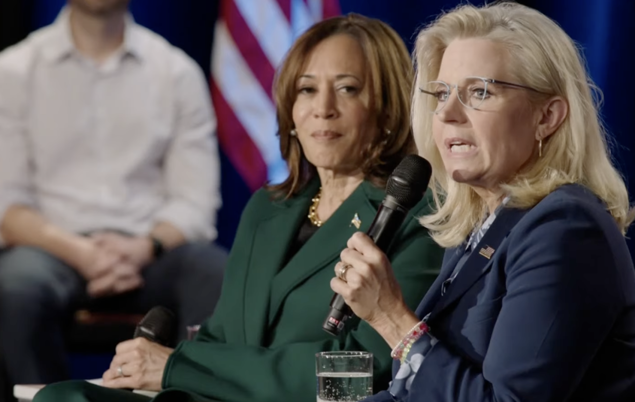 Republican former U.S. Rep. Liz Cheney is sitting down, speaking into a microphone. Kamala Harris sits next to her