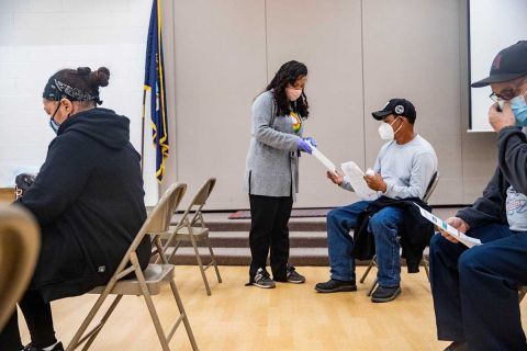 Claudia Pohlen of the Hispanic Center of Western Michigan passes out information about Michigan’s redistricting process during a COVID-19 vaccination clinic this month in Wyoming. 