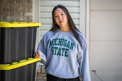 Sophia Yee standing next to boxes