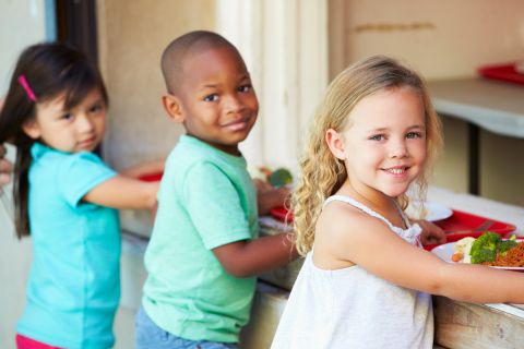 Children stand in lunch line.