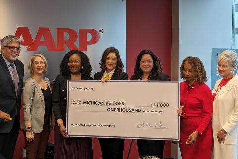 Gov. Gretchen Whitmer holding check