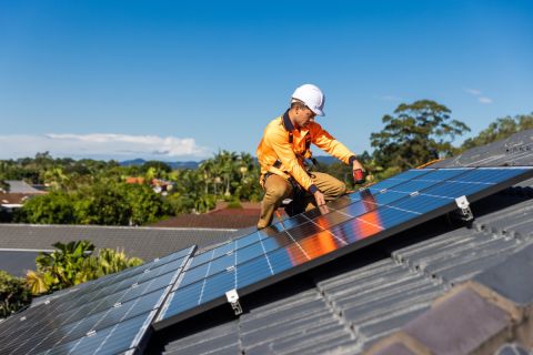 Man installing a solar panel on the roof