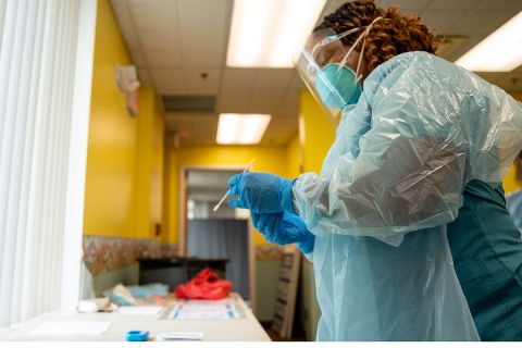 Beth Schuckman, an emergency medical technician, processes a COVID test at New Hope Wellness Center