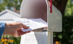 someone putting things in a mailbox