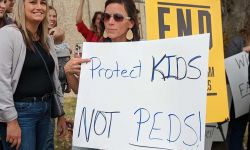 woman holding protect kids sign