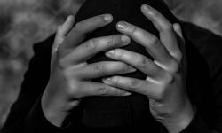 boy covering face black and white photo