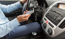 close up of man with smartphone driving car