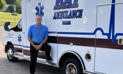 Gary Wadaga standing in front of an ambulance 