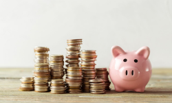 piggy bank with coins stacked next to it