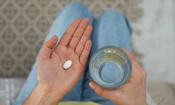 young woman holding a pill