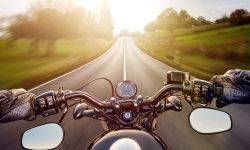 POV shot of young man riding on a motorcycle. Hands of motorcyclist on a street