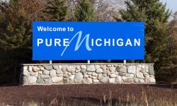 Blue welcome to pure michigan sign on a stone wall 