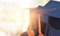  The back image of the graduates wearing a yellow tassel hat