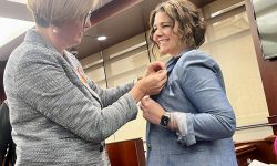 woman pinning a ribbon on another woman