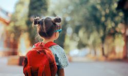  Child wearing a backpack ready for the first day of kindergarten