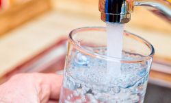  Point of view shot of a man pouring a glass of fresh water from a kitchen faucet