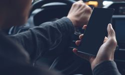 Mock up of man using mobile smart phone inside a car.