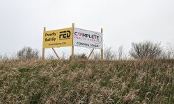 sign for the clare campus project. it's a yellow and white sign next to each other