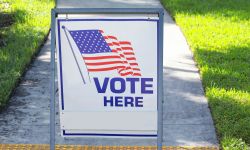 Vote here sign placed on the walkway to a neighborhood polling place