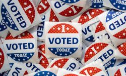 Top view of pile of Voting stickers. The stickers are red, white and blue