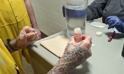 Someone getting methadone. The photo is close up of a man's hands