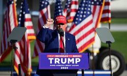 Donald Trump stands a podium