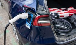 A blue EV being plugged in 