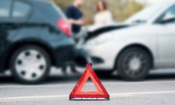 People discussing after a car crash and trying to find an agreement , main focus on the red triangle sign