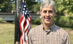 Greg Talberg standing next to an American flag