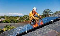 Man installing a solar panel on the roof